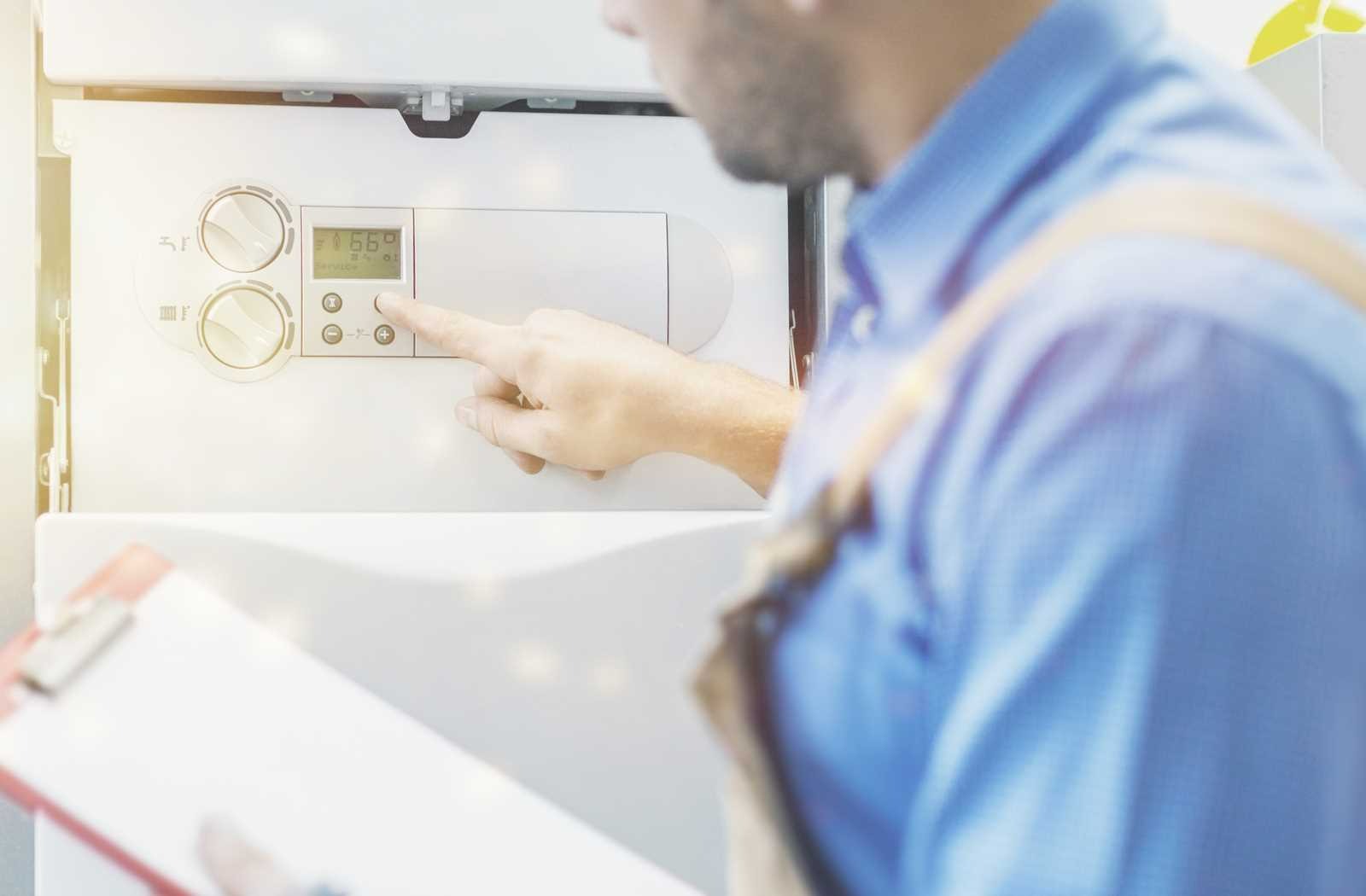 A technician adjusting the settings on a water heater